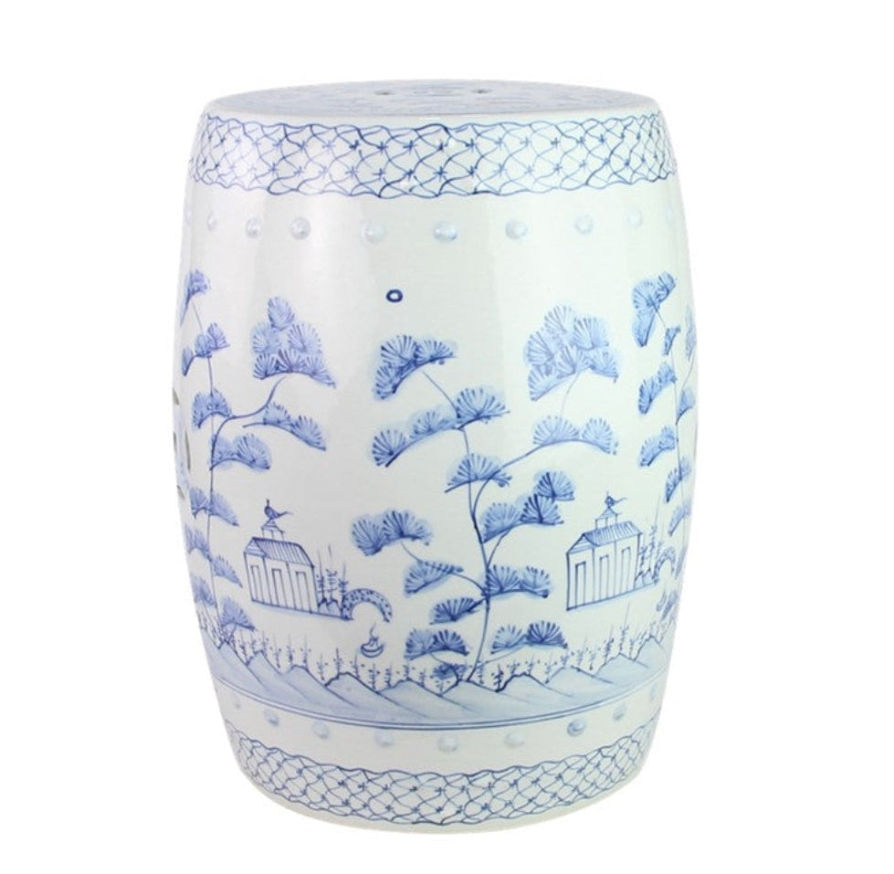 A round ceramic garden stool with a white glaze and blue hand-painted chinoiserie style design featuring pine trees, ginkgo leaves, small pavements, and decorative borders.
