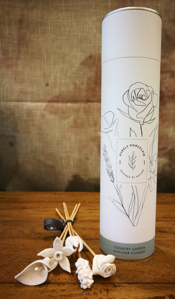 White cylindrical container with floral design on a wooden surface