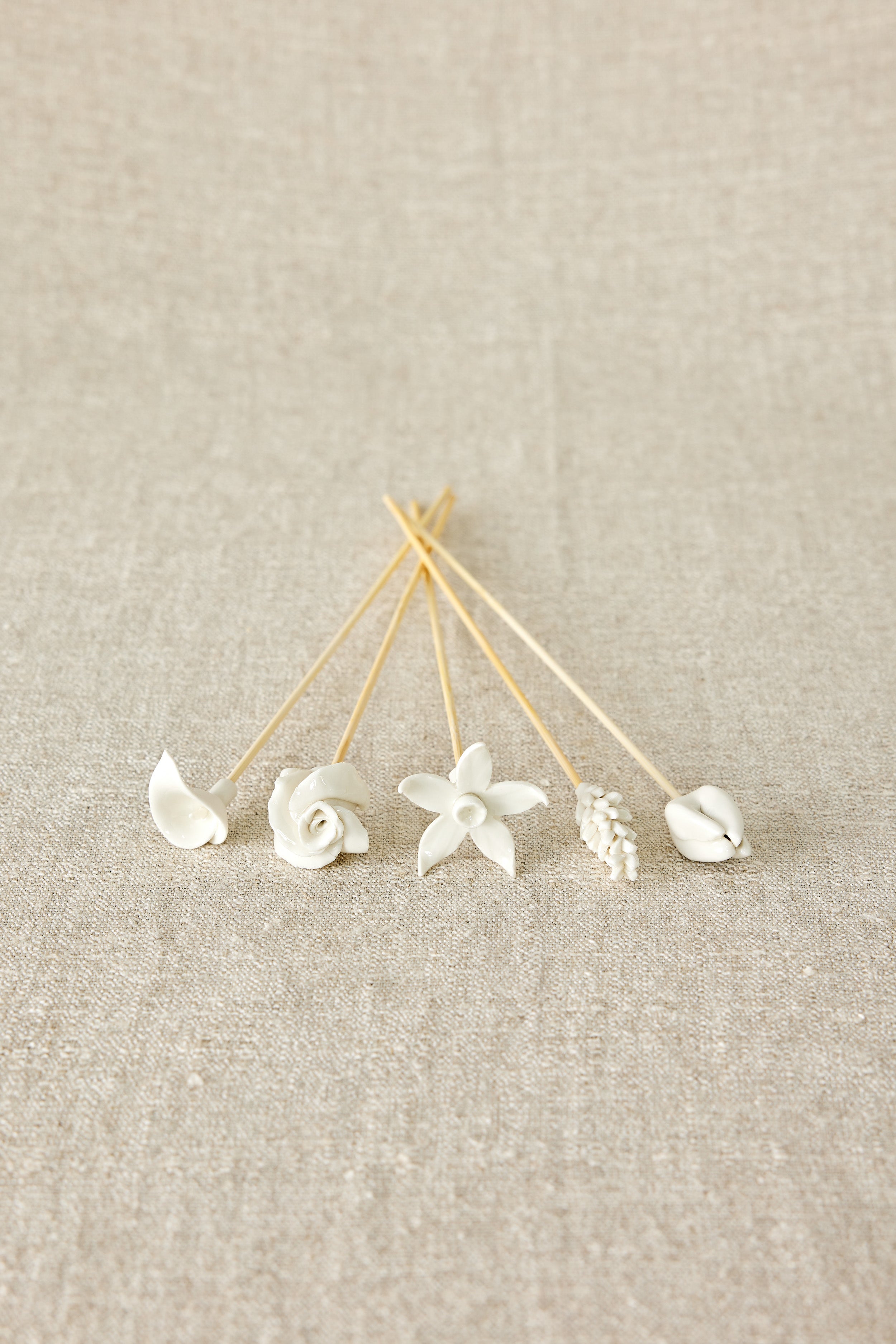 Decorative floral diffuser sticks against a beige background
