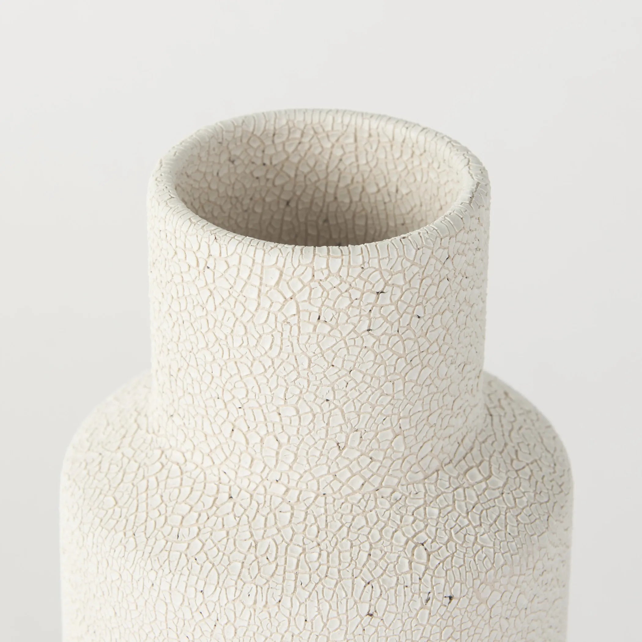 White ceramic vase with a textured surface on a light gray background