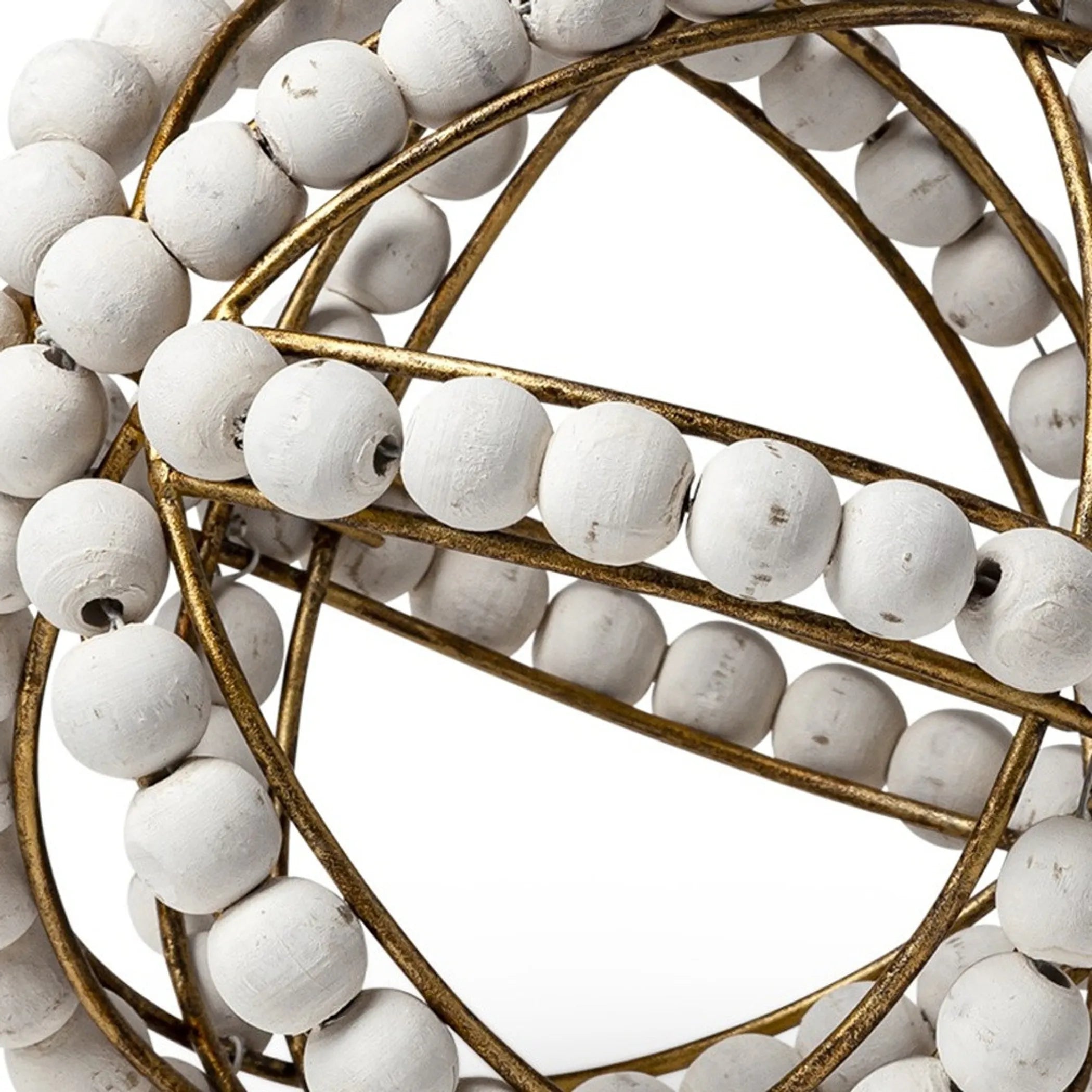 Close-up of a decorative sphere with white beads and gold metalwork on a white background