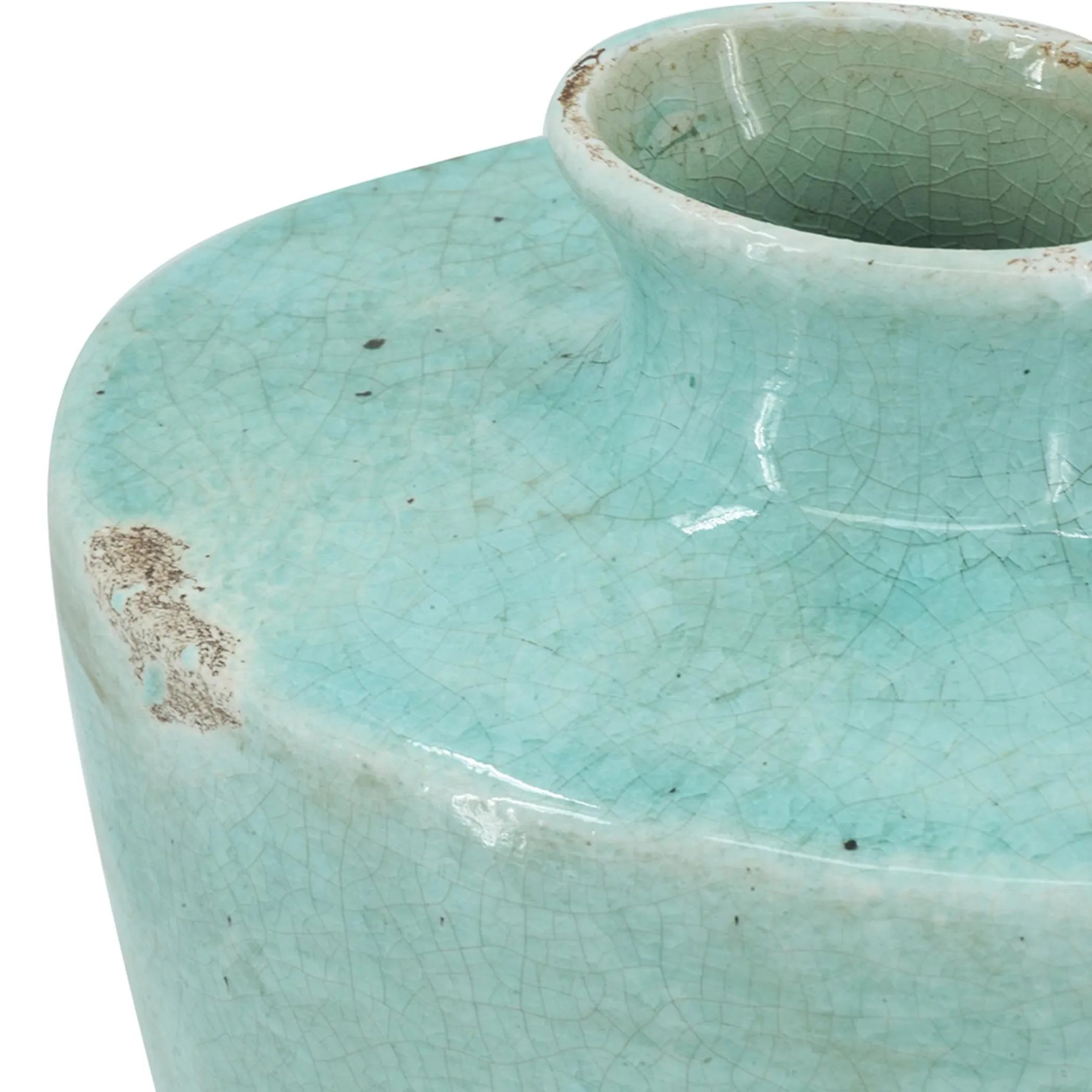 Close-up of a turquoise ceramic vase with a textured surface.