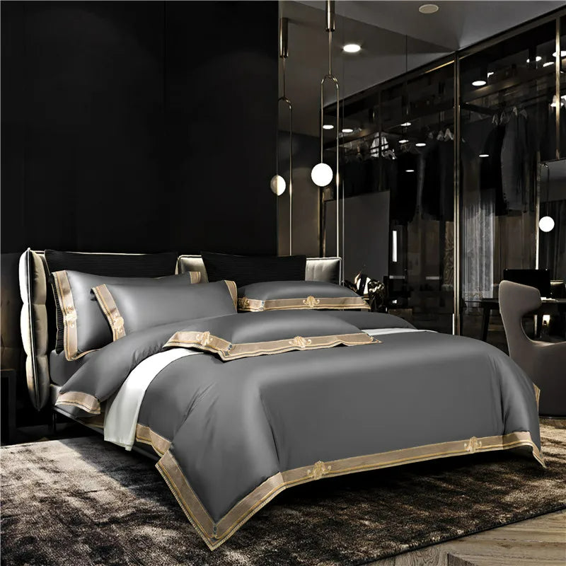 Gray bedding set with gold accents on a bed in a modern bedroom.