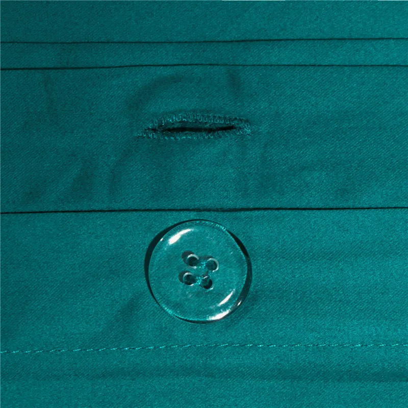 Close-up of a teal button on a textured fabric background
