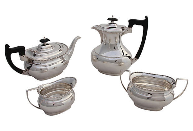 Silver tea set with teapot, coffee pot, milk jug, and sugar bowl on a white background