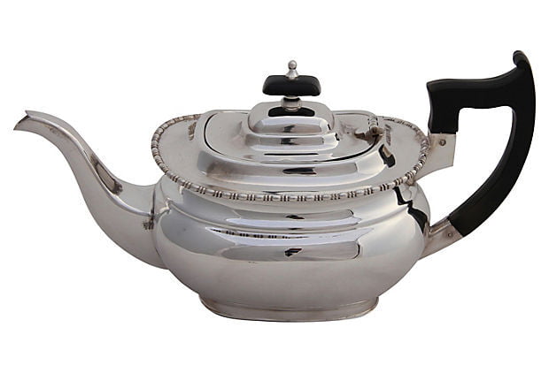 Antique Silver teapot with black handle and lid knob on a white background