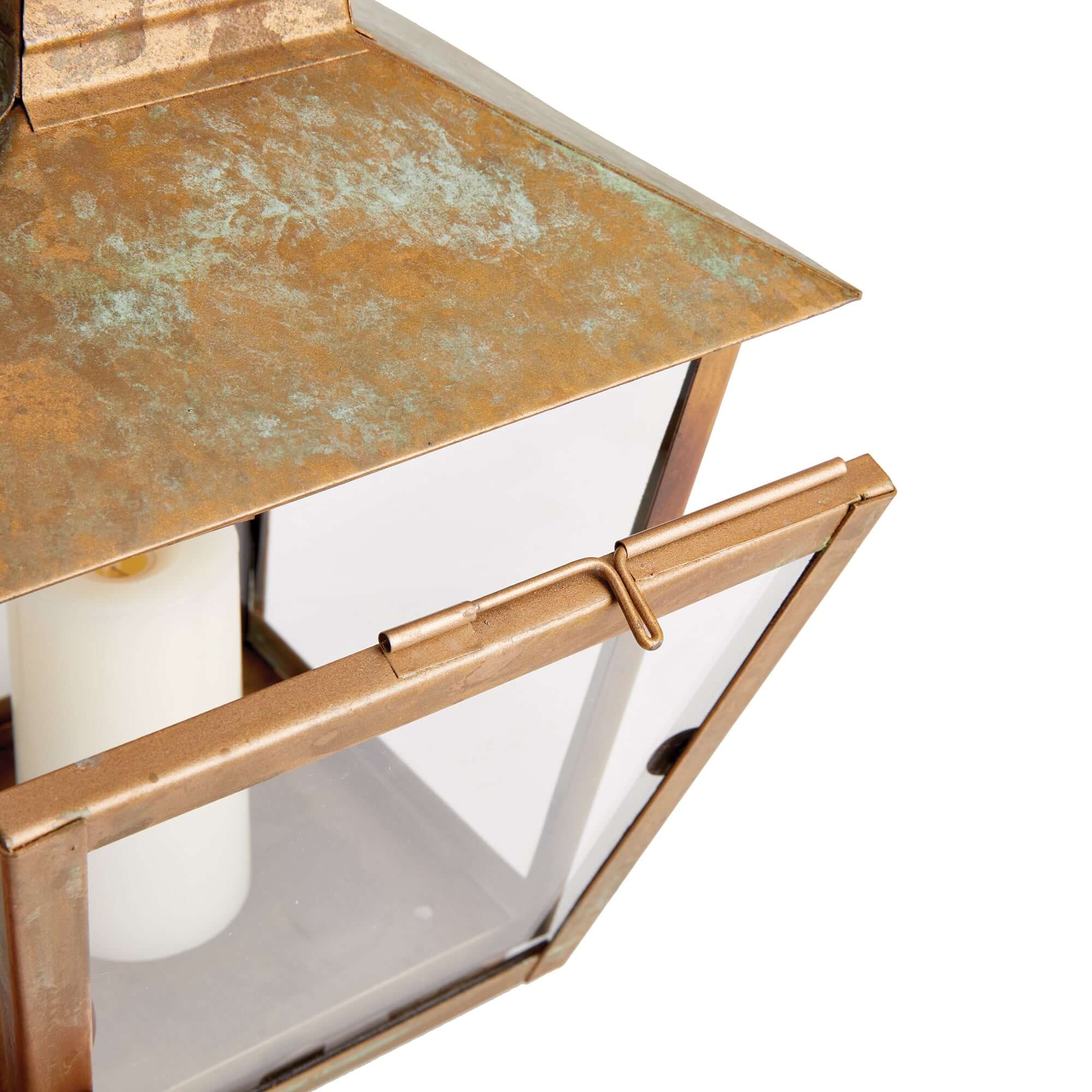 Bronze lantern with a white candle inside on a white background