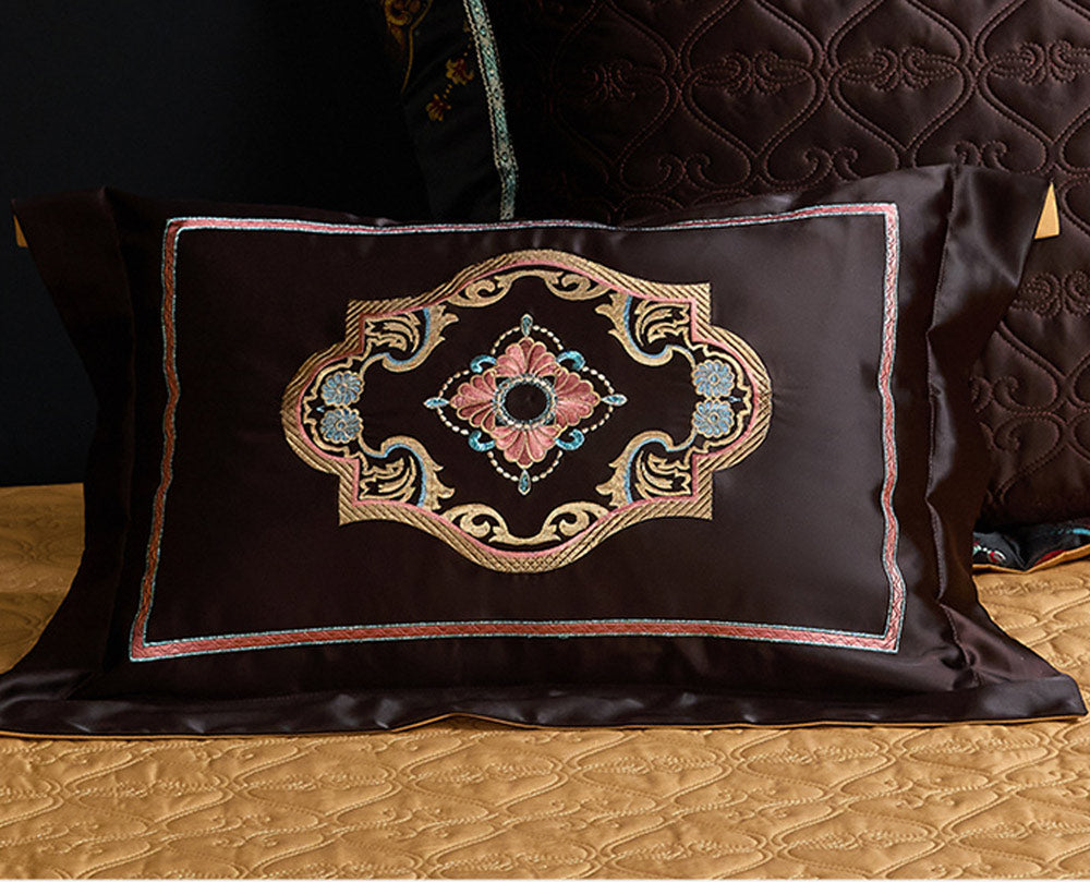Decorative pillow with intricate embroidery on a quilted surface