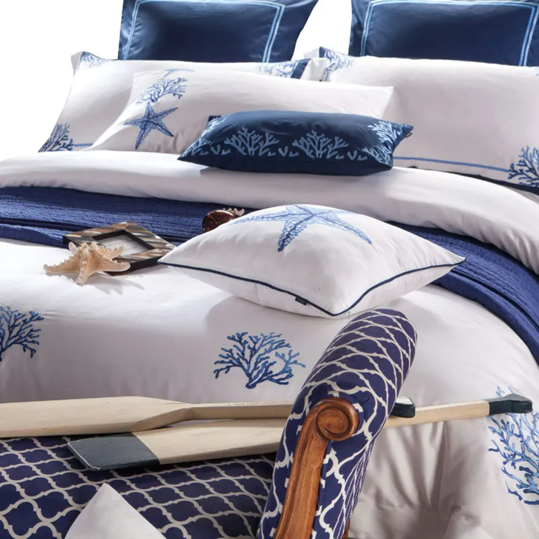 Nautical-themed bedding set with blue and white patterns on a bed.