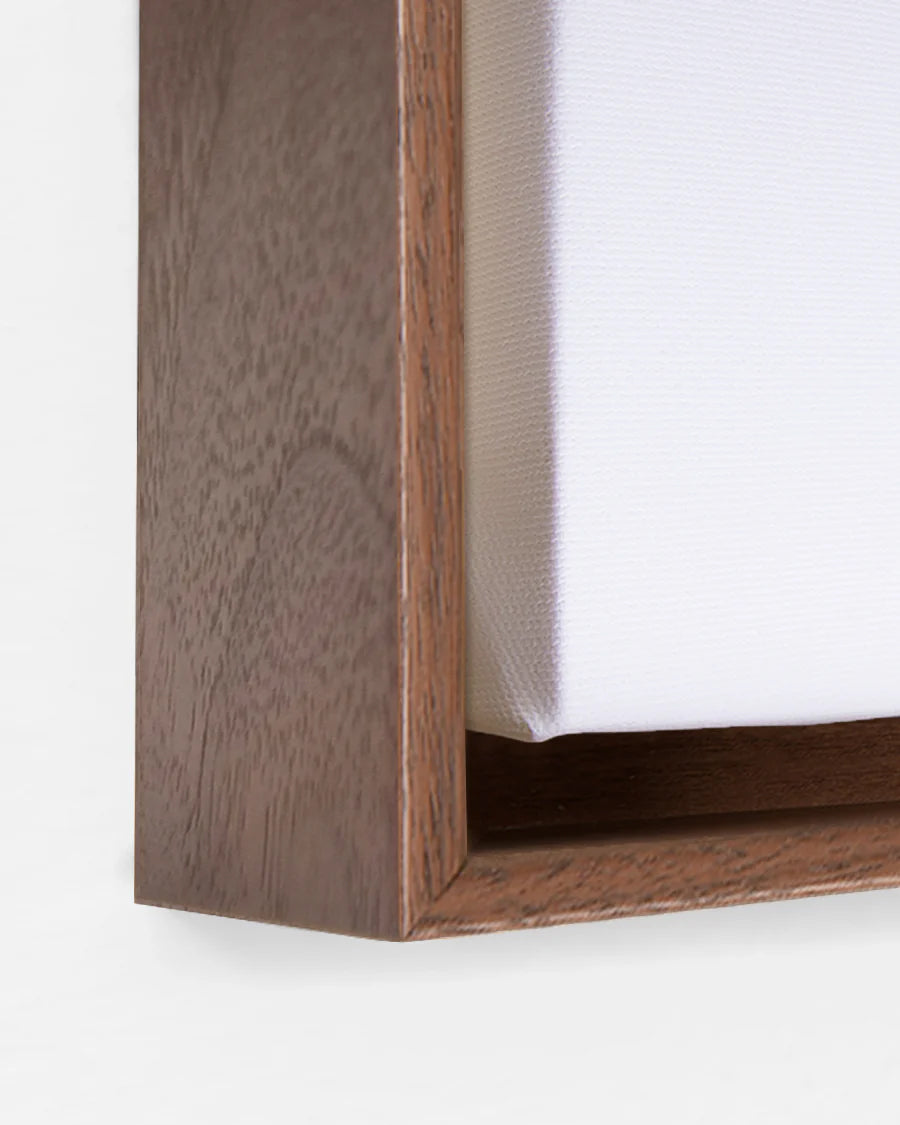 Close-up of a walnut canvas floating frame on a white background