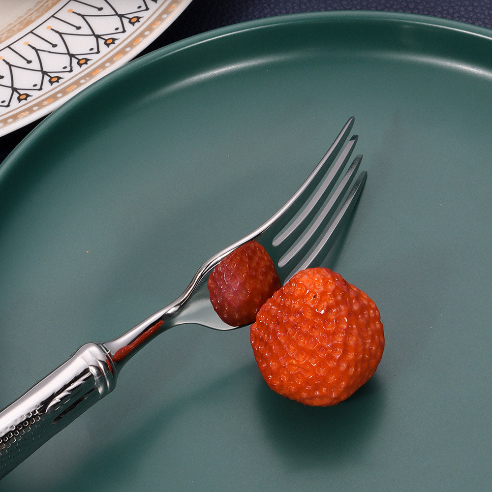 Fork with two small round food items on a green plate