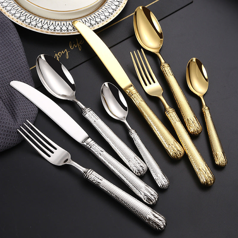 Set of silver, gold, and bronze flatware on a dark surface with 'Joy Life' branding.