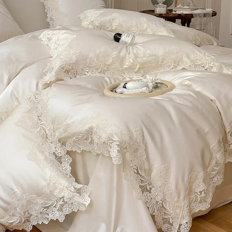 Luxurious white lace bedding set on a bed with a bottle of wine.