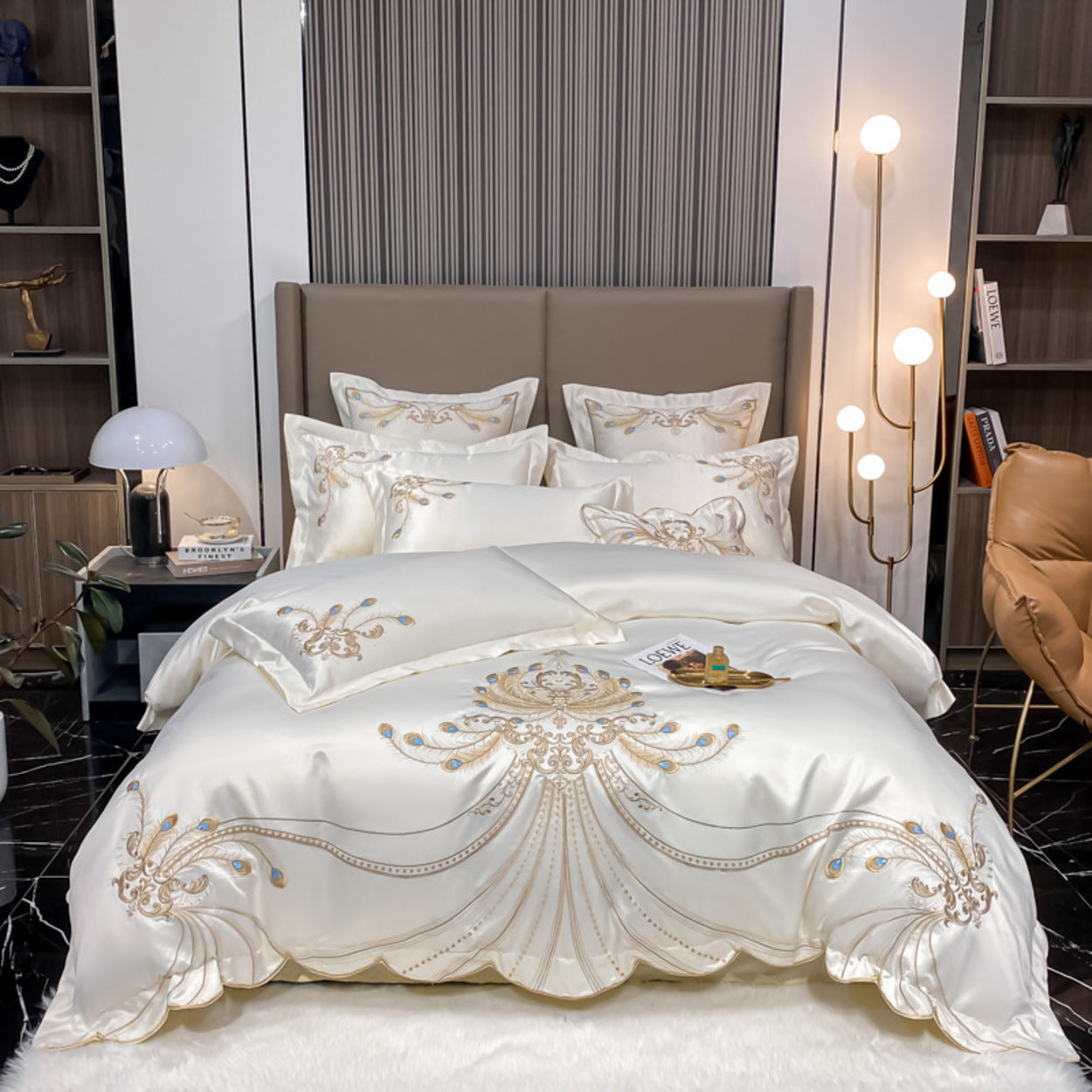 Luxurious bed with embroidered bedding in a modern bedroom setting.