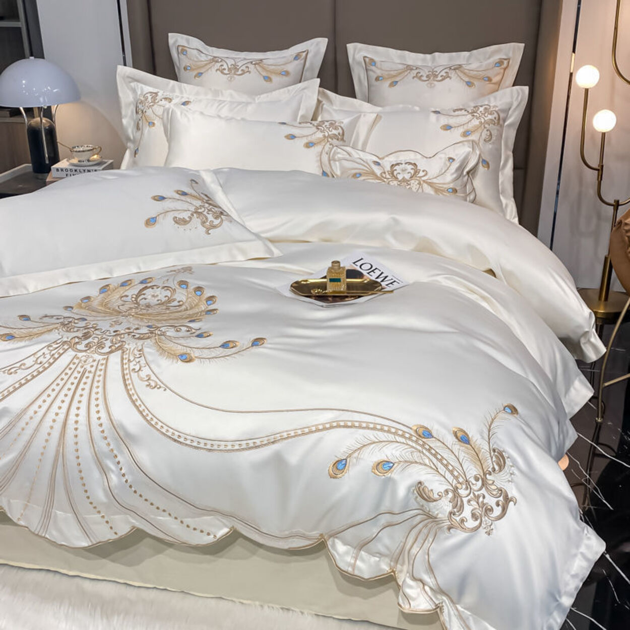 Luxury white bedding set with gold embroidery in a bedroom setting