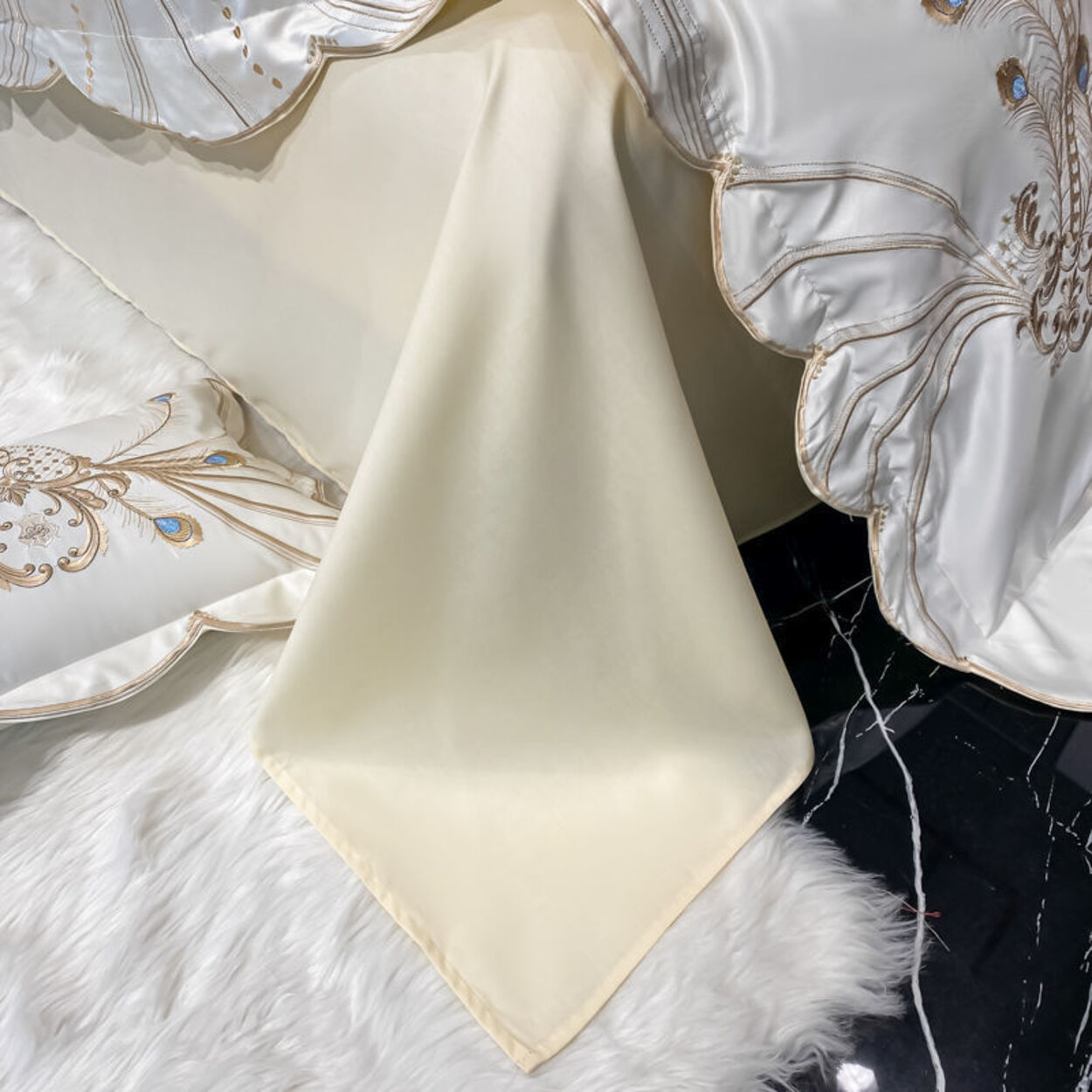 Cream-colored fabric square on a textured surface with decorative elements