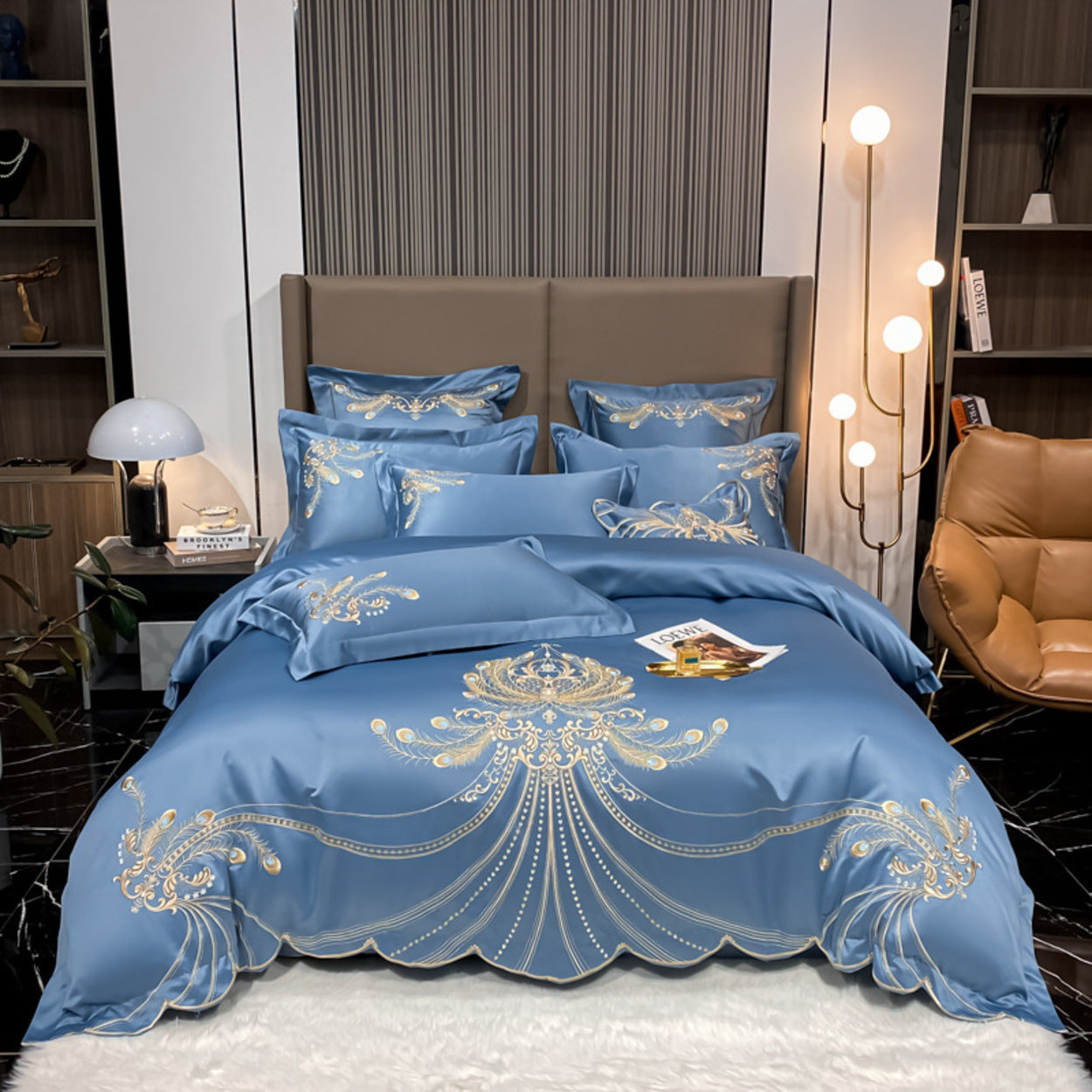 Blue embroidered bedding set on a bed in a bedroom setting.