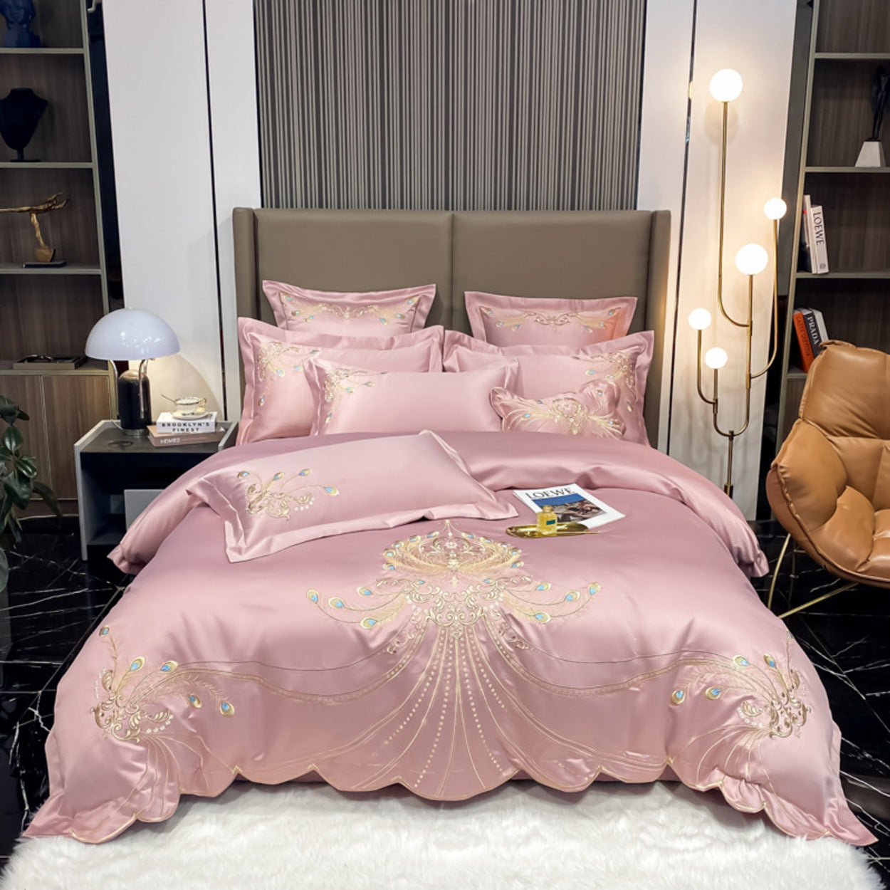 Pink embroidered bedding set on a bed in a stylish bedroom.