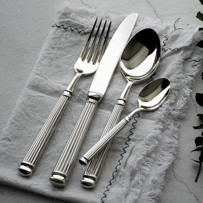 Silver cutlery set on a textured gray surface