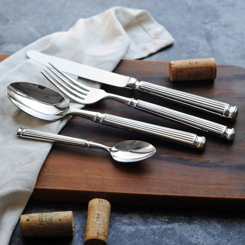 Silver cutlery set on a wooden board with wine corks