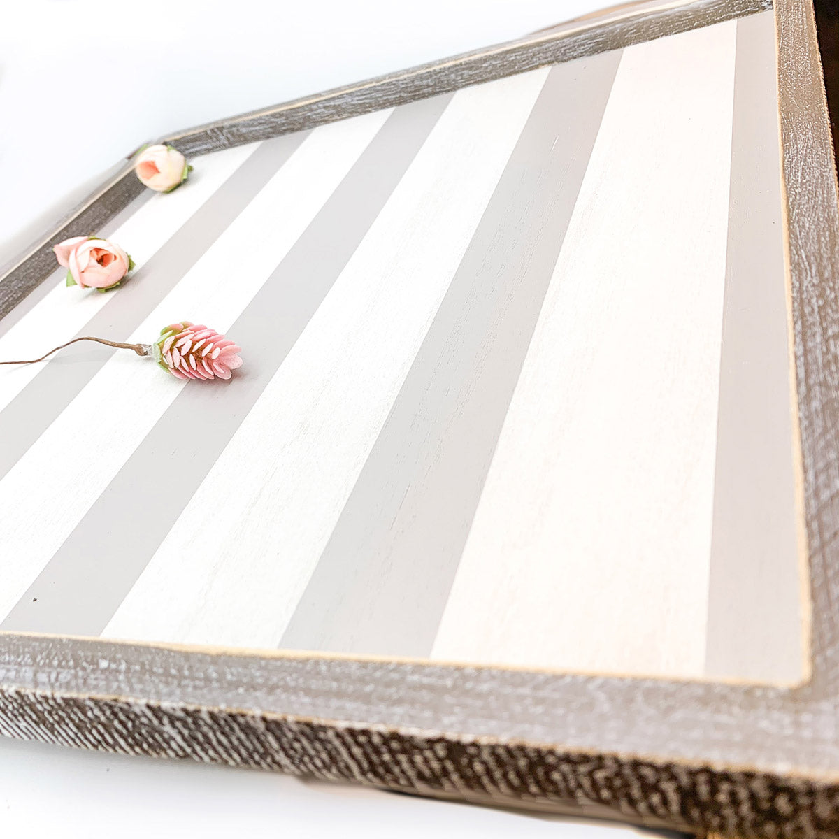 Decorative wooden tray with floral elements on a white background