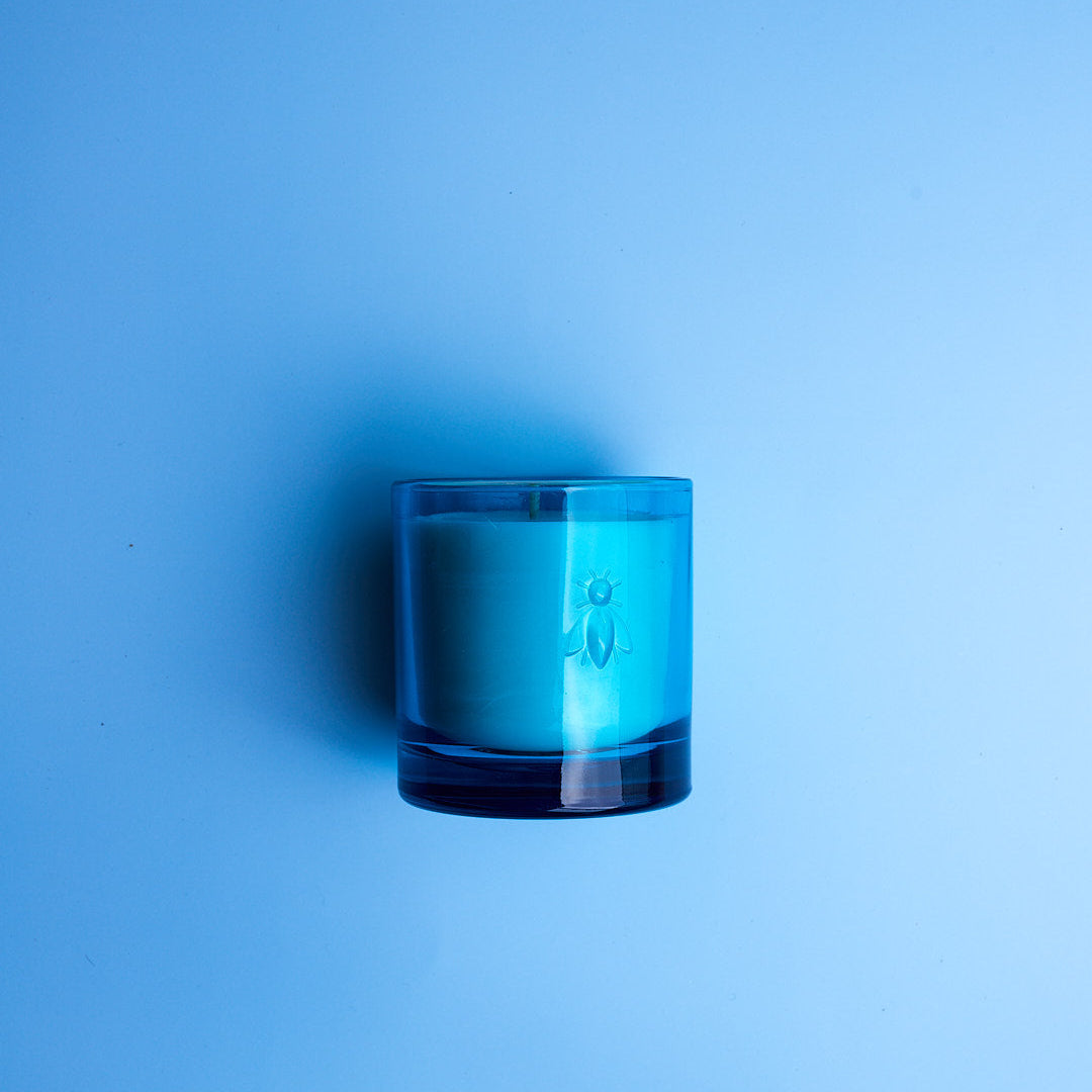 La Rochère Clear glass candle holder with blue rim on a solid blue background
