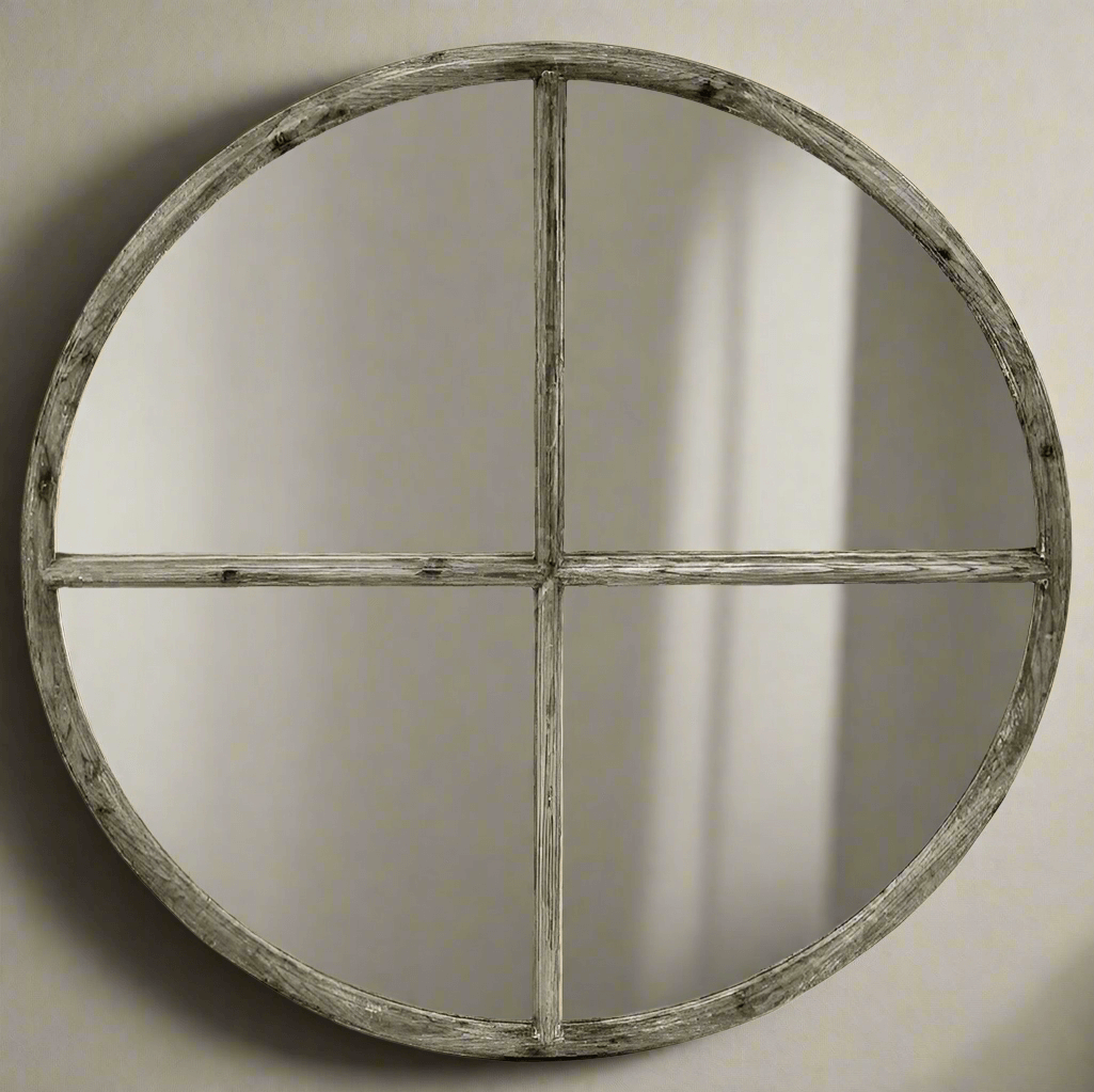Round mirror with a rustic wooden frame on a plain wall