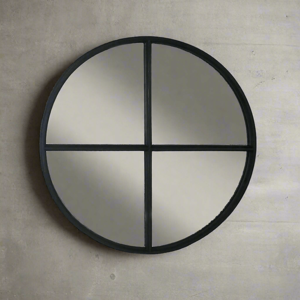 Round wall mirror with black frame on a beige wall