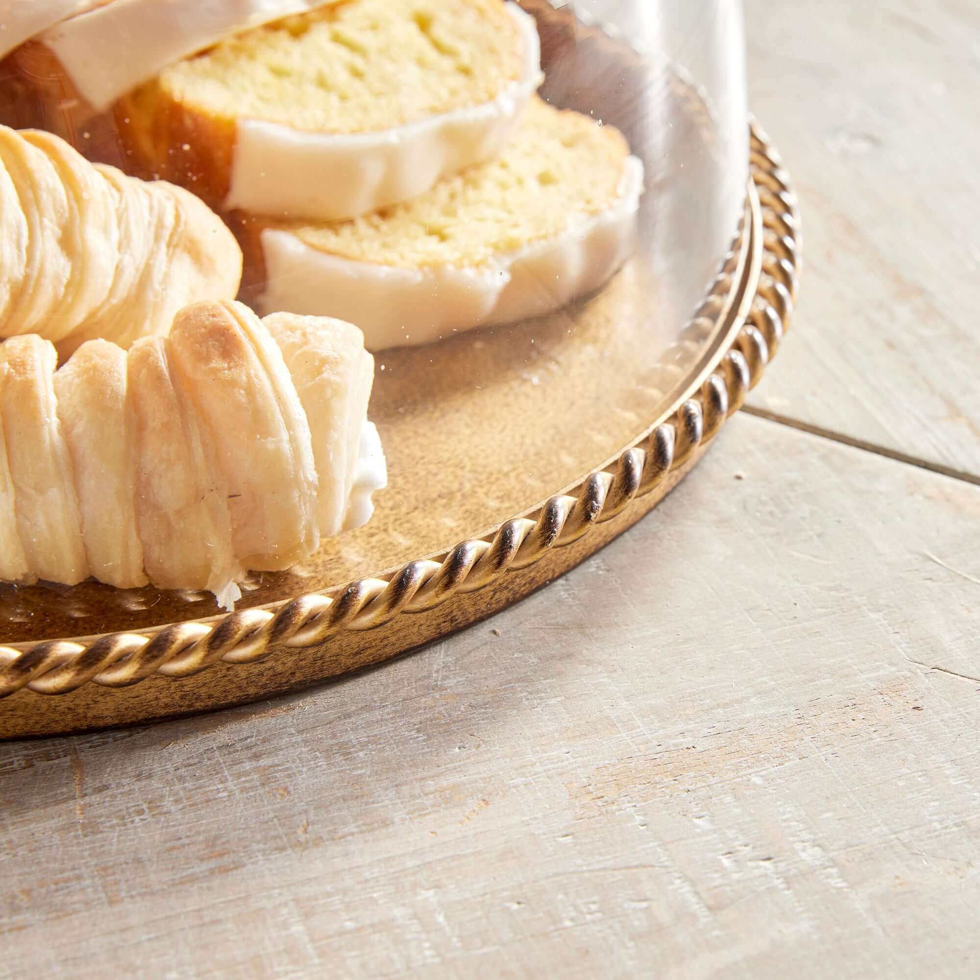 Rolls of bread on a decorative gold plate on a wooden surface