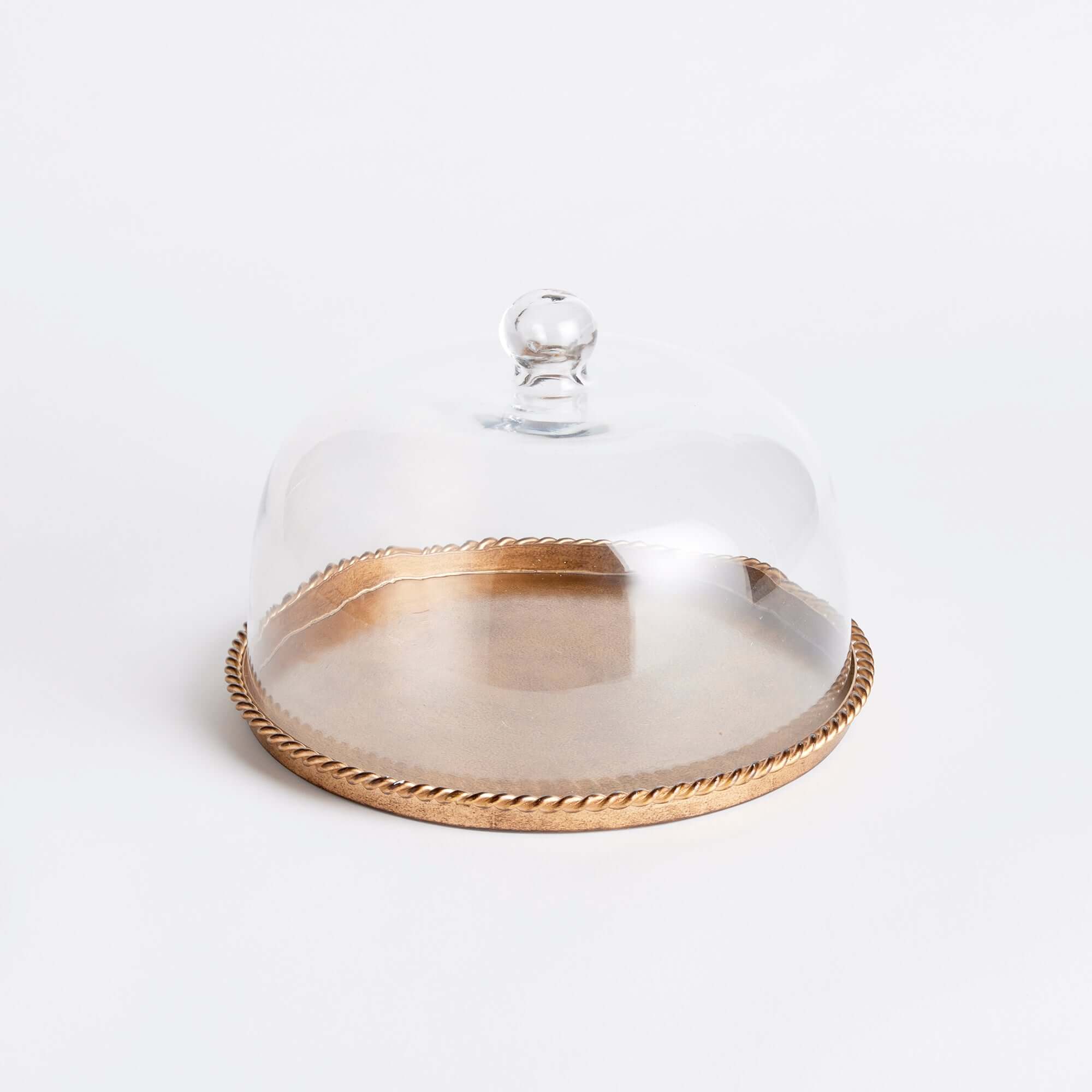 Decorative dish with a glass cover and gold rim on a white background