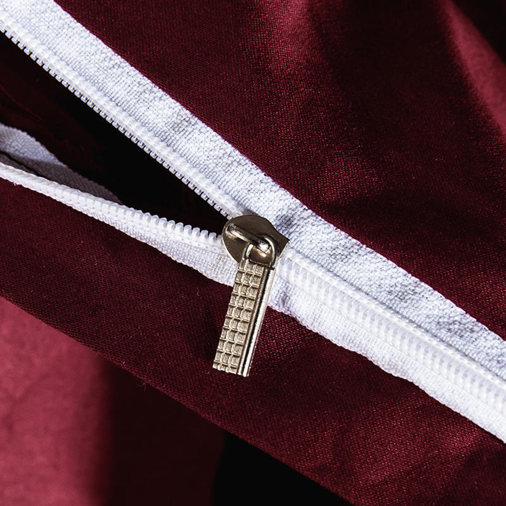 Close-up of a zipper on a maroon garment with white lining.