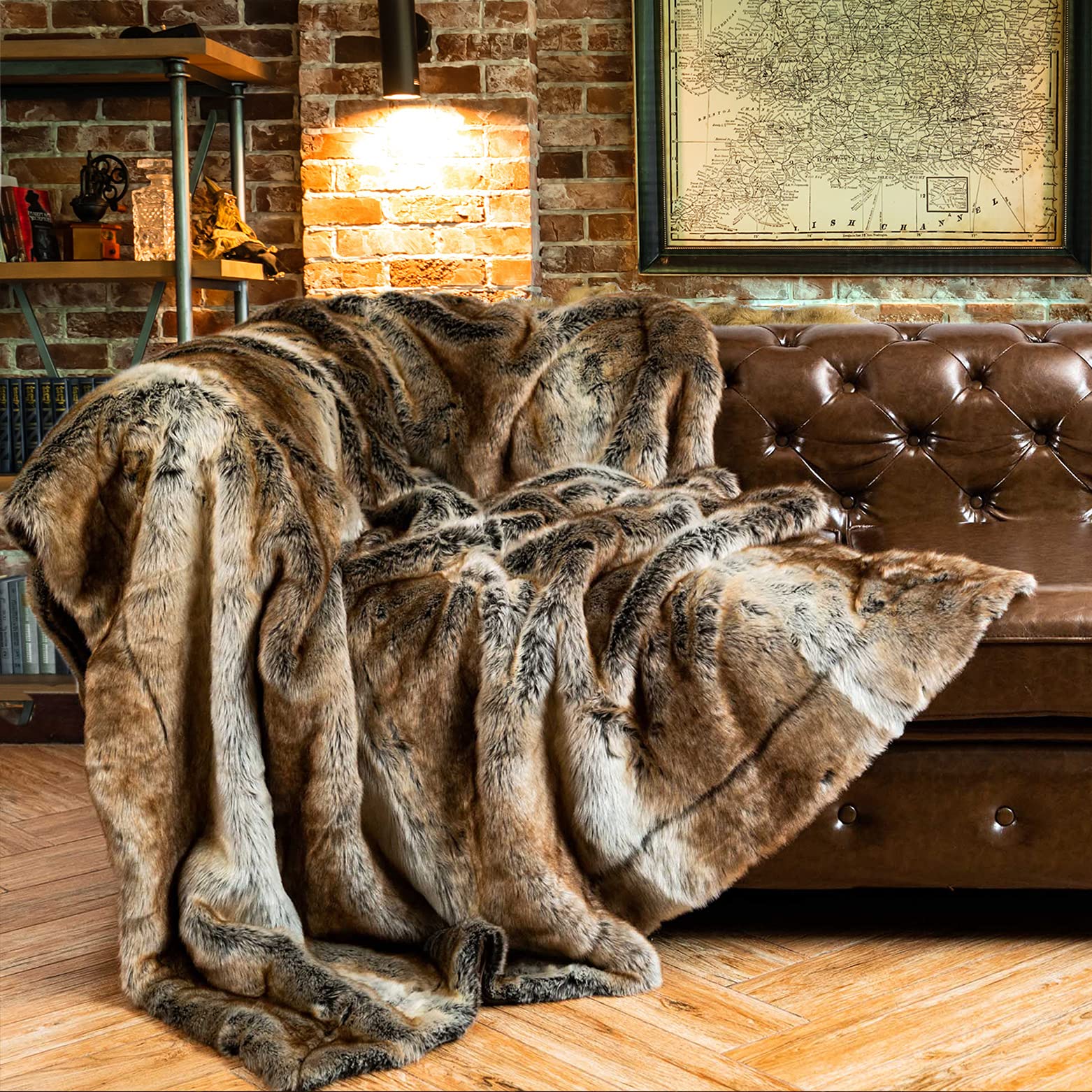 Brown fur throw blanket draped over a brown leather sofa in a cozy room with brick walls and a map.