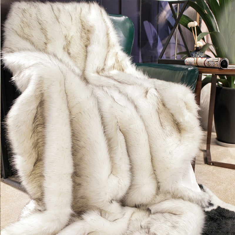 White fur throw blanket draped over a chair in a room with decor elements.