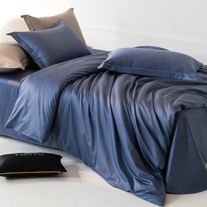 Blue bedding set on a bed with pillows and a visible brand logo.