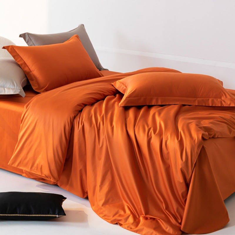 Orange bedding set on a bed with pillows and a white background