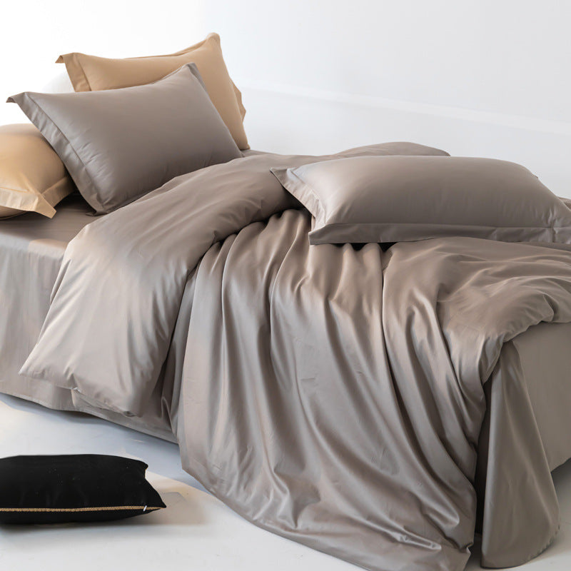 Bed with gray bedding and pillows on a white background