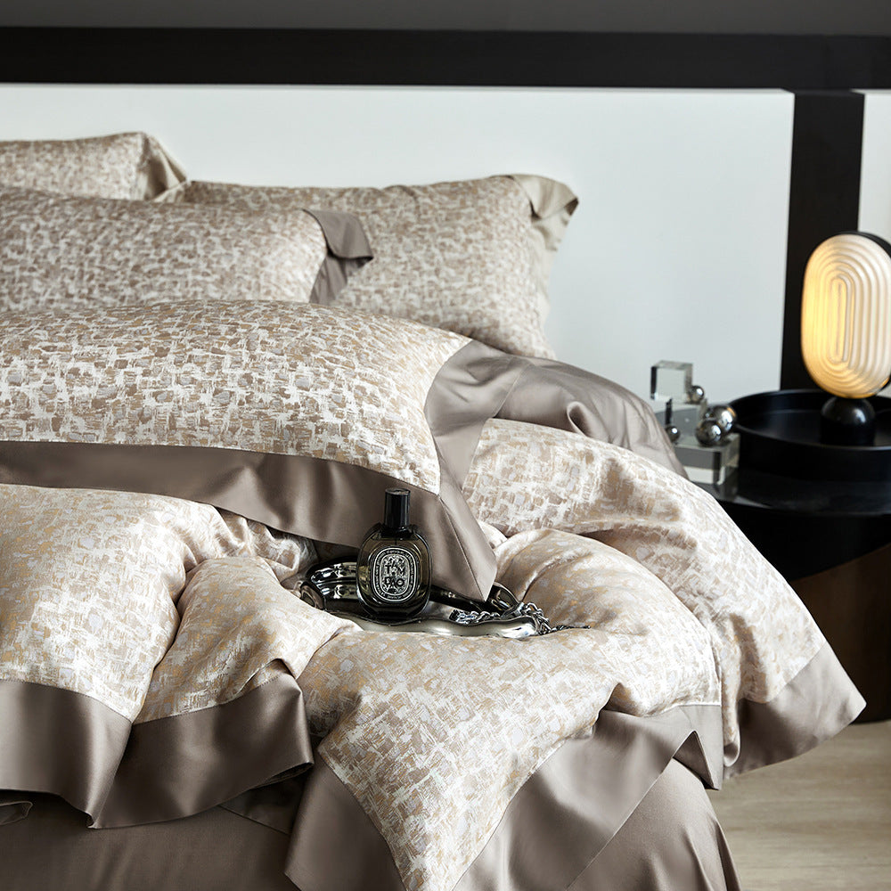 Patterned bedspread on a bed with a nightstand in the background