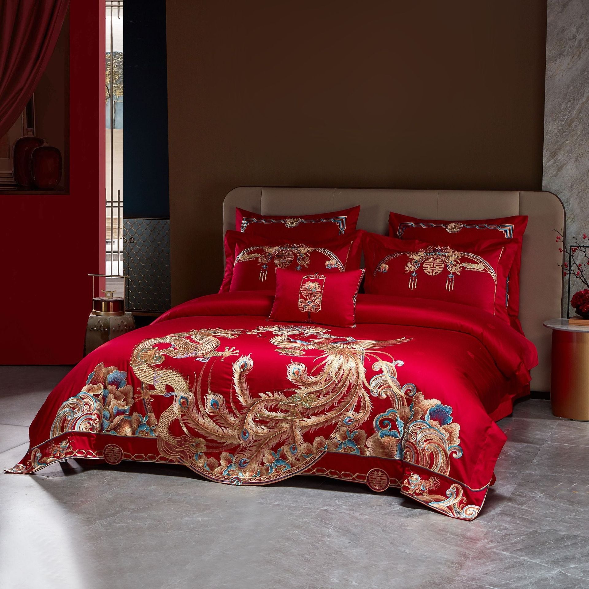 Red embroidered bedding set on a bed in a room with a red wall.