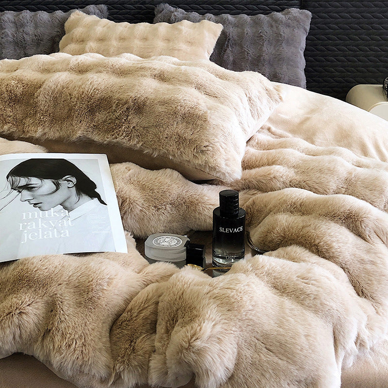 Beige faux rabbit fur bedding with a magazine and a bottle of Slevine on top