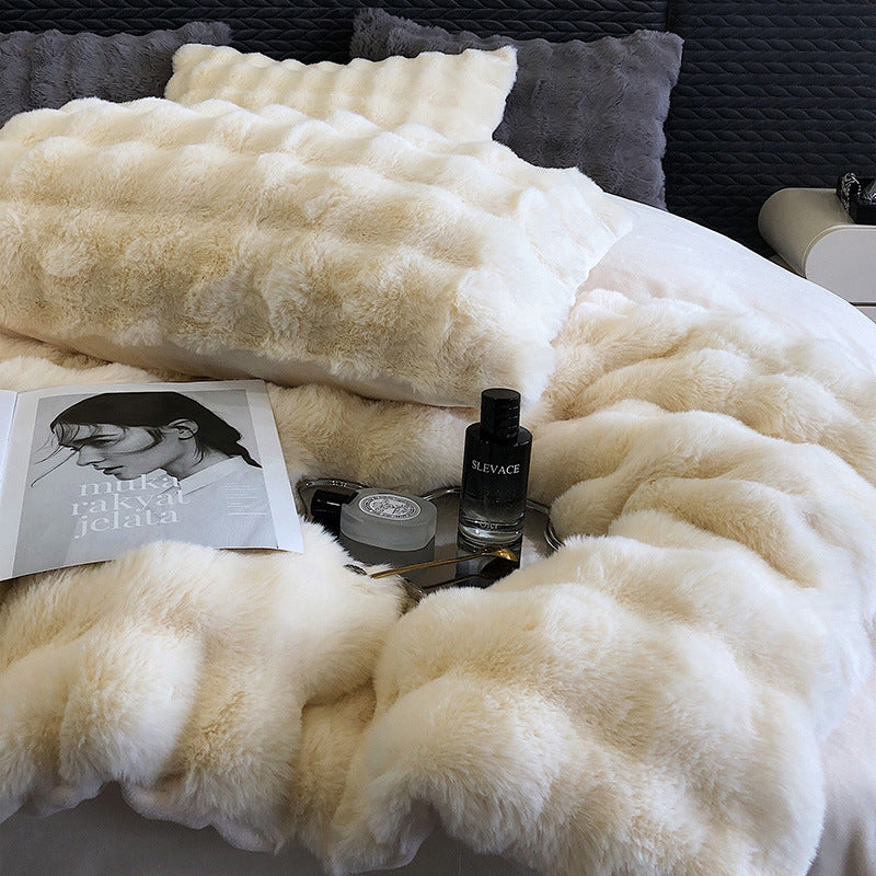faux rabbit fur bedding with a magazine and two bottles on top, against a dark textured wall.
