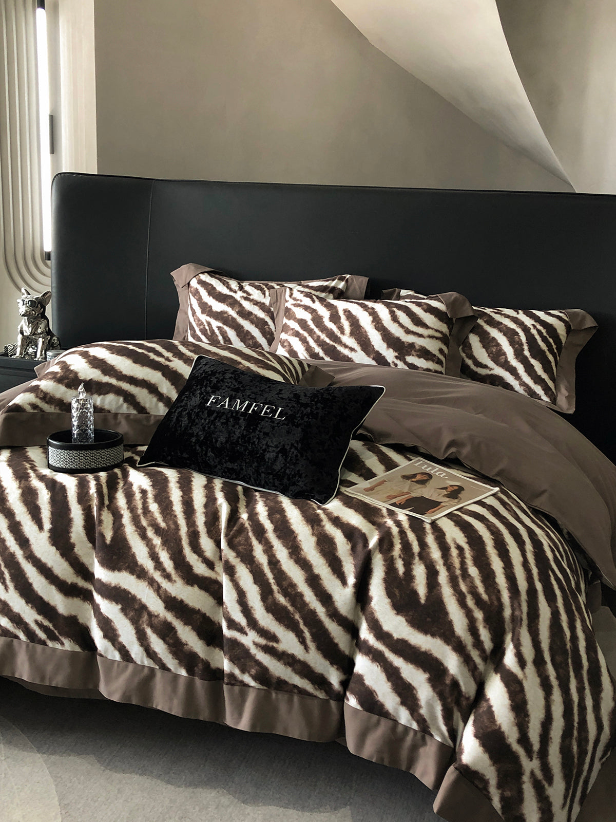 Bed with zebra print and brown bedding, featuring a 'Famfel' pillow.