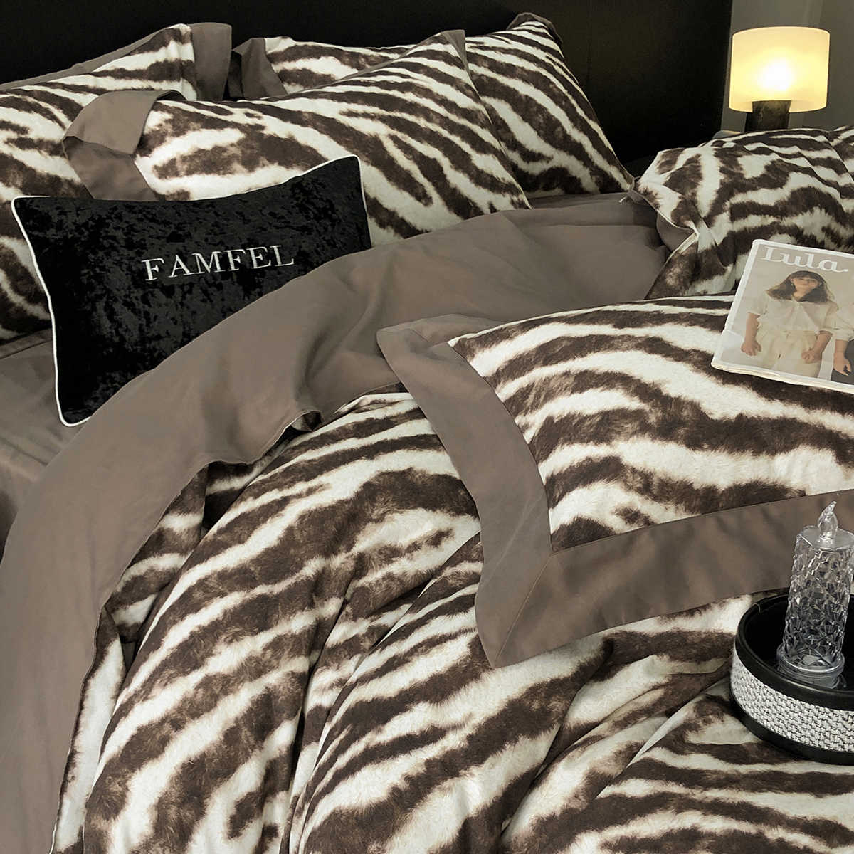 Bed with zebra print bedding and pillows, featuring a Famfel pillow.