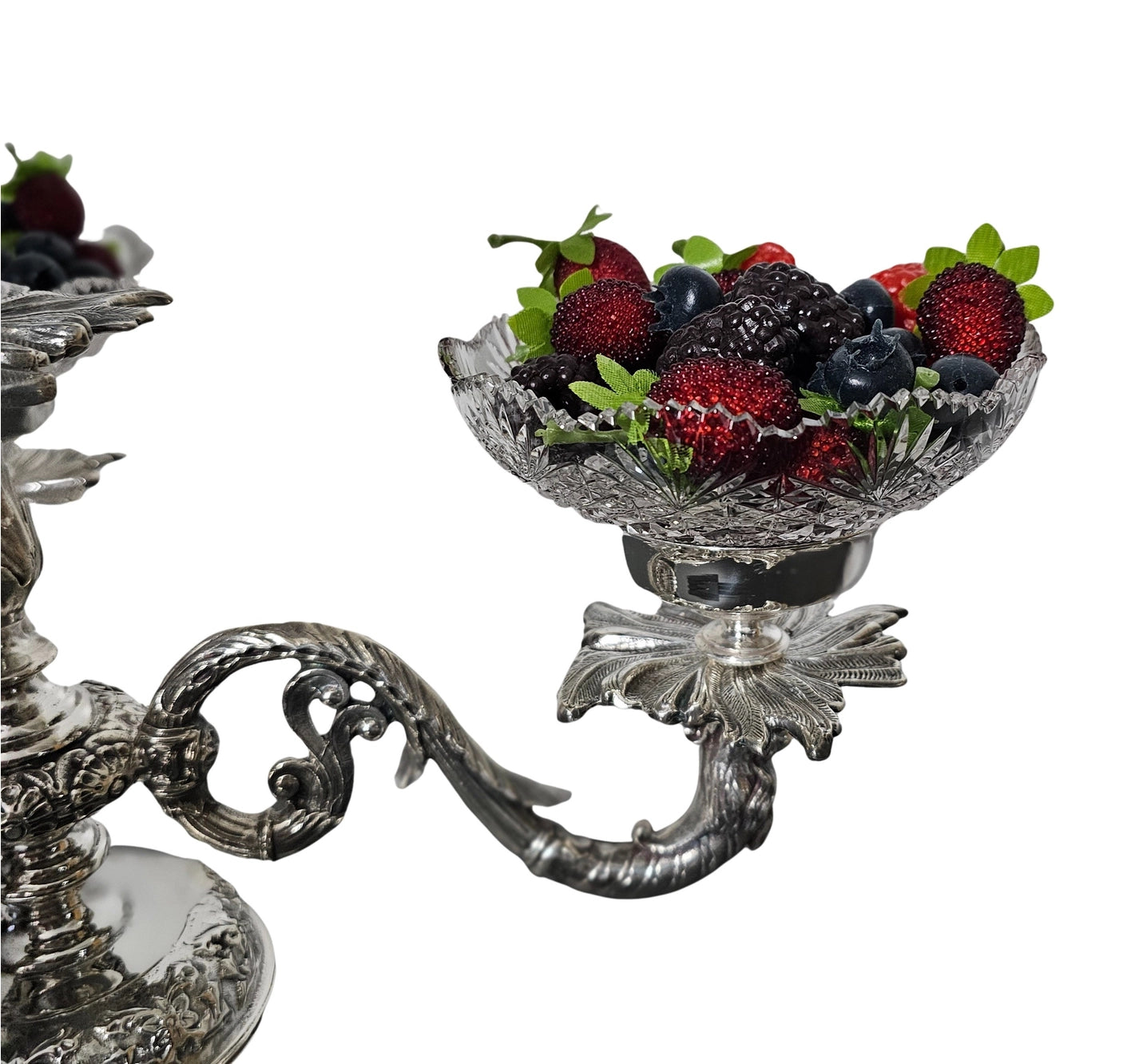 Decorative silver bowl with fruit on a white background
