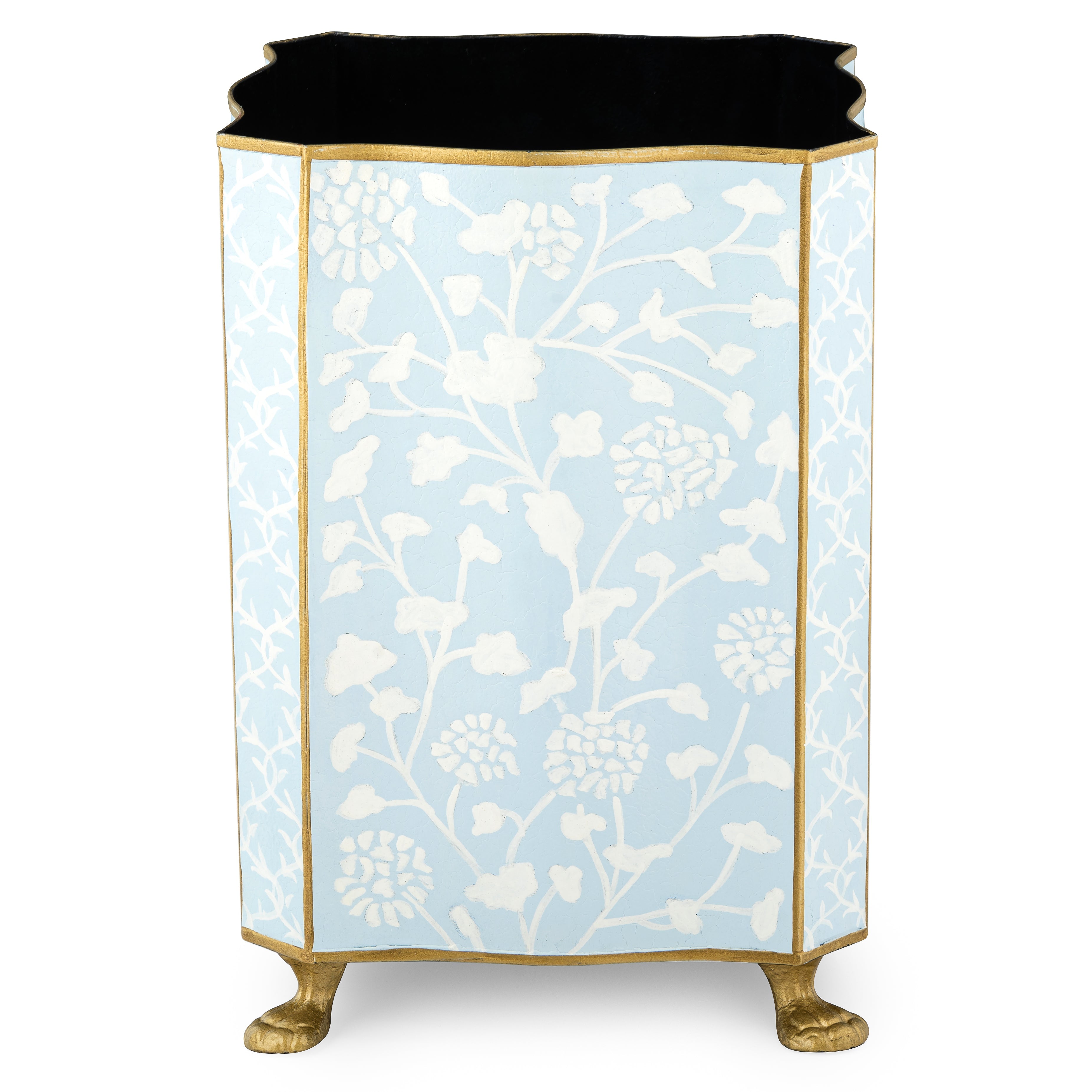 Decorative pale blue and white wastepaper basket with gold feet and floral pattern on a white background