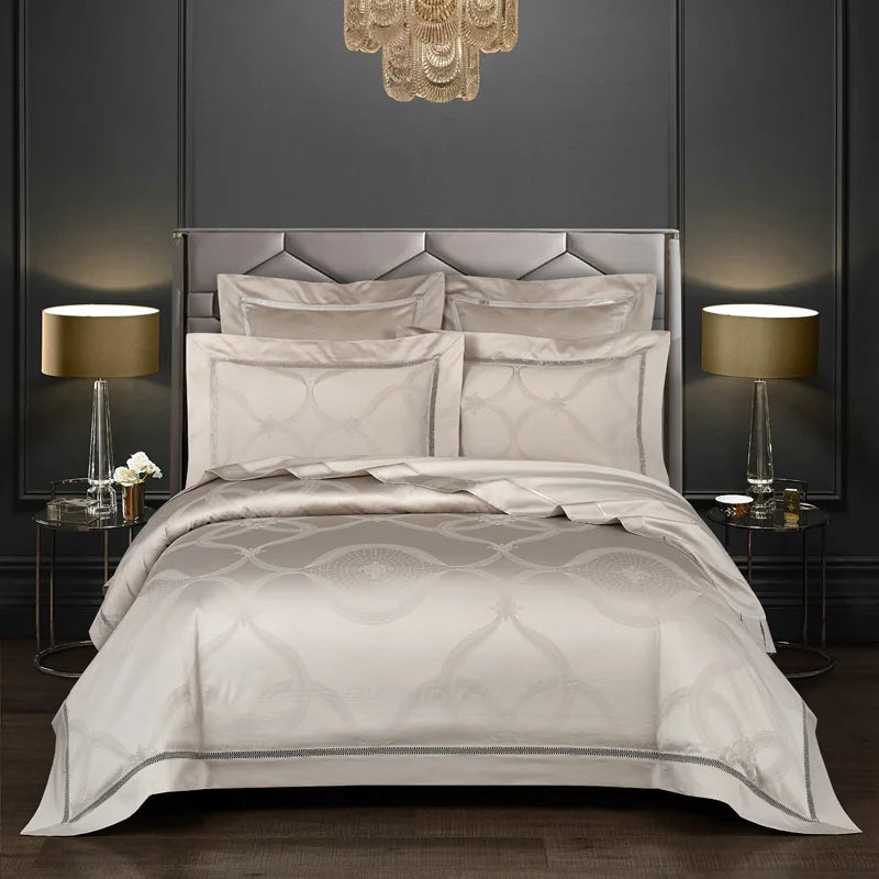 Luxurious bedroom with gray bedding and matching headboard against a dark wall.