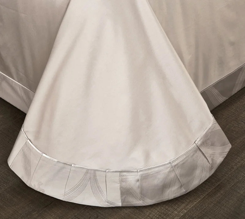 Close-up of a bed skirt with decorative hem on a bed.