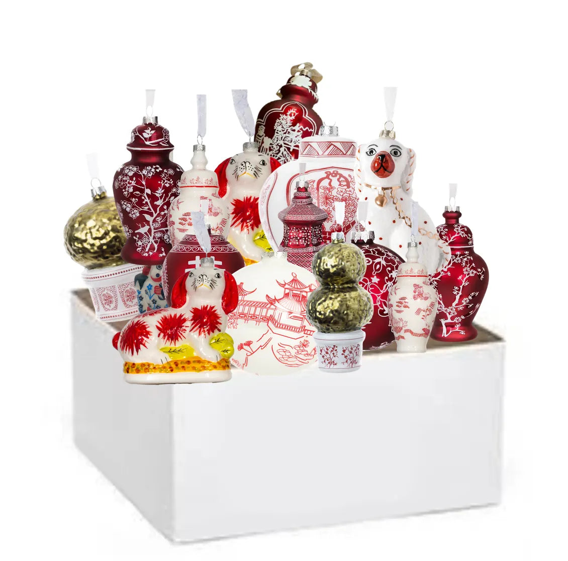 Collection of holiday ornaments including vases, bottles, and figurines in a white box.