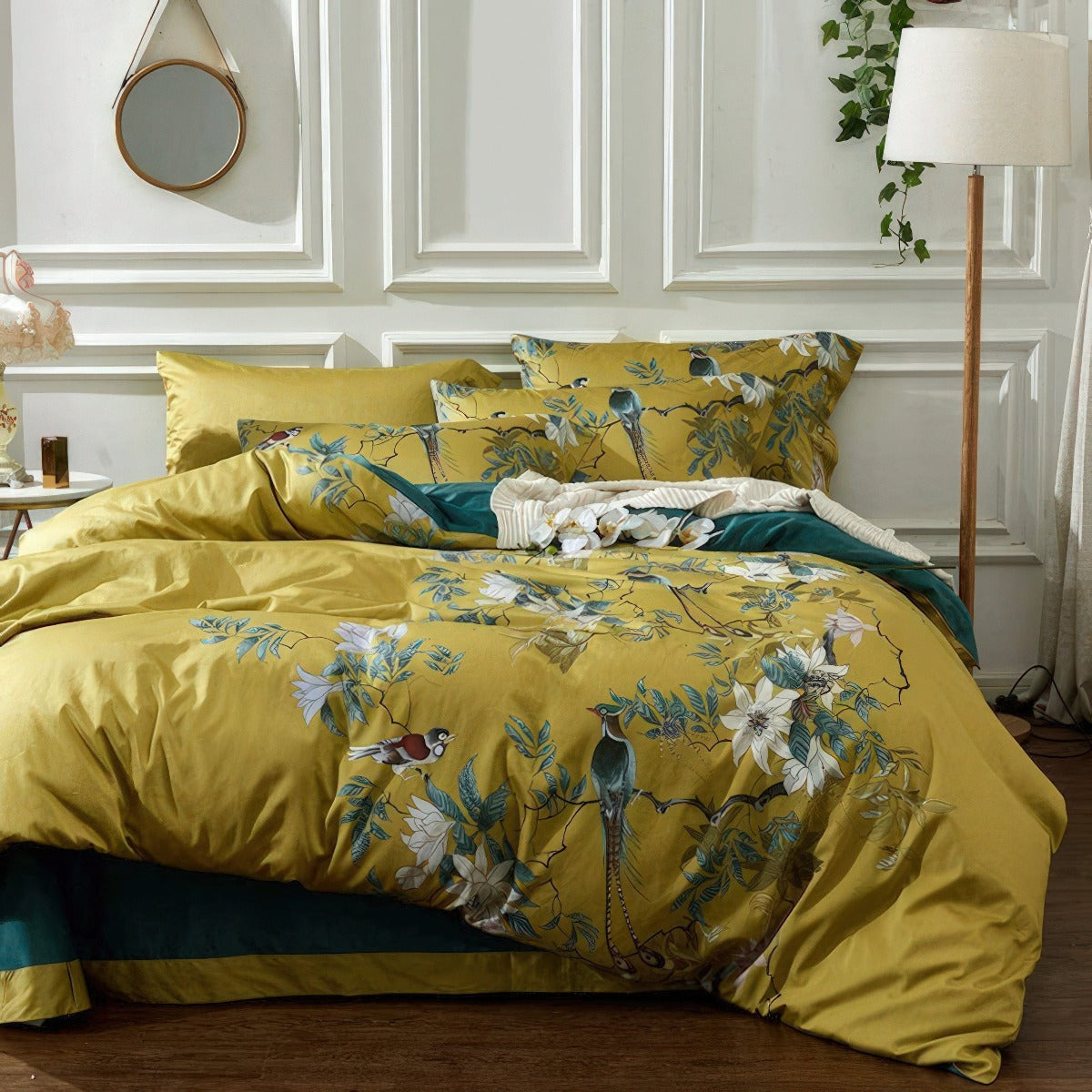 Yellow floral and bird patterned bedding set on a bed in a bedroom.