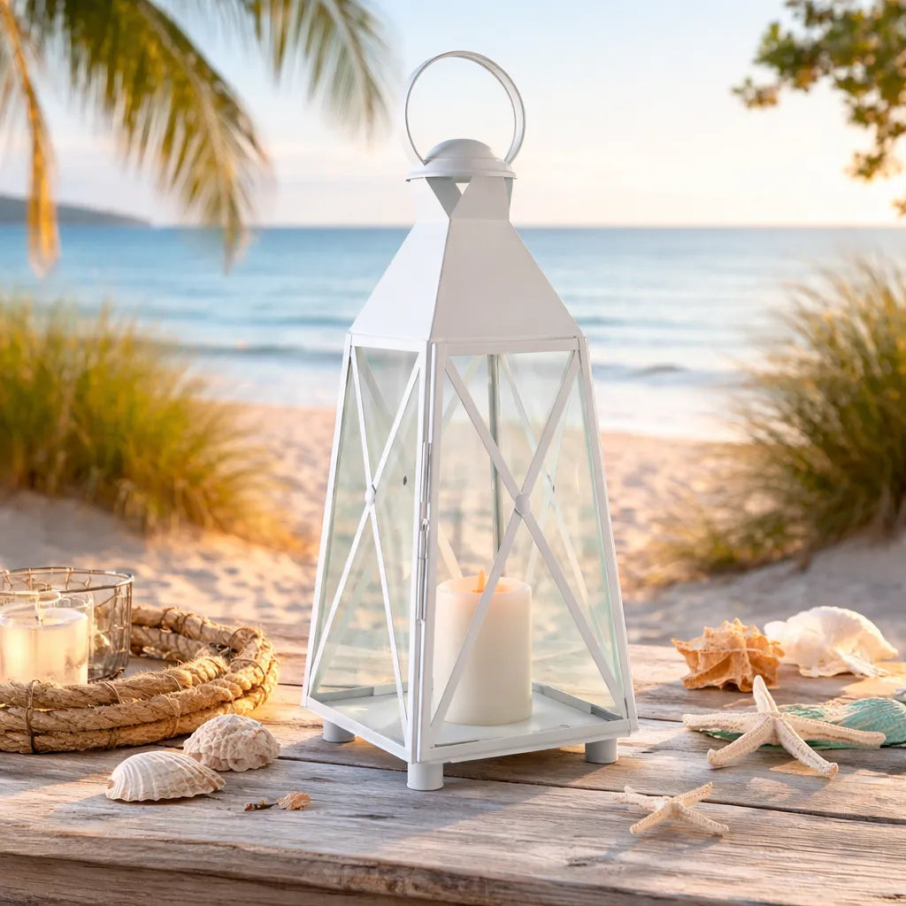 White X frame lantern with a candle on a wooden surface by the beach