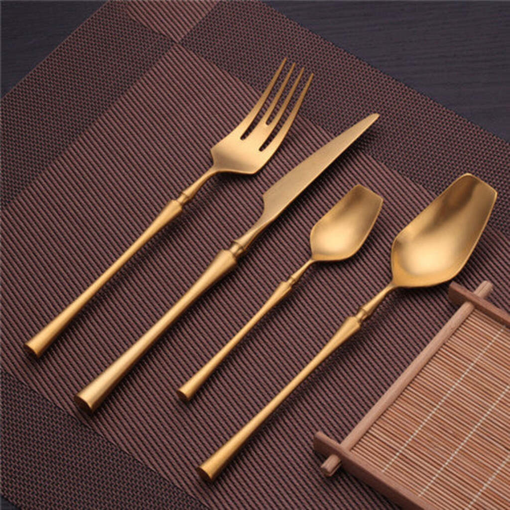 Set of gold-colored cutlery on a textured brown surface